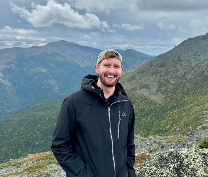 Jon smiling on a mountain summit in the White Mountains